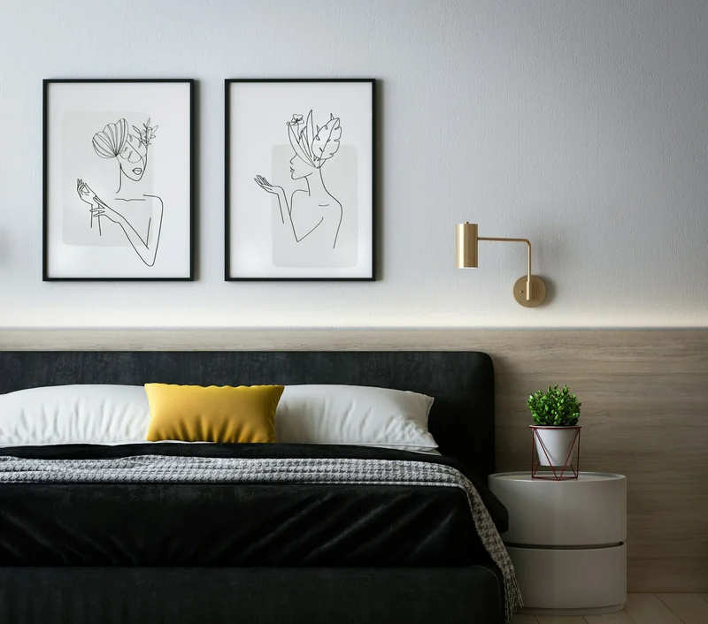 A modern bedroom with framed prints above the bed
