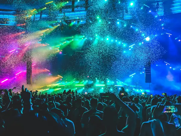A crowd at a concert lit by stage lights
