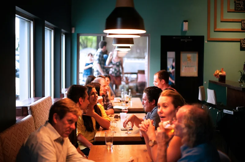 People eating together at a long table in a restaurant