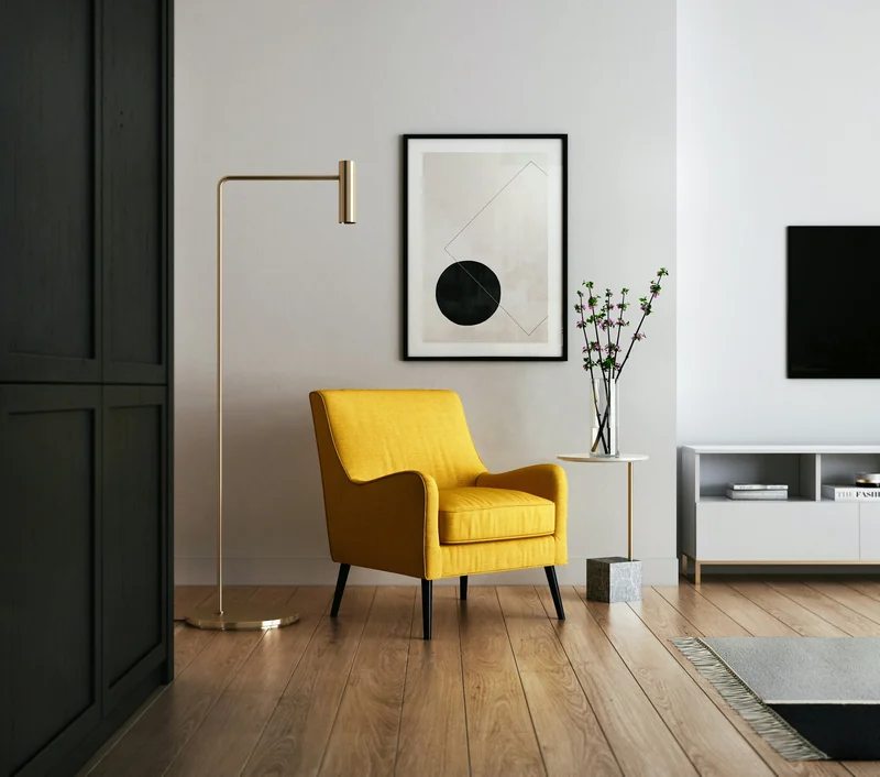 A yellow armchair in a bright, sparsely furnished room